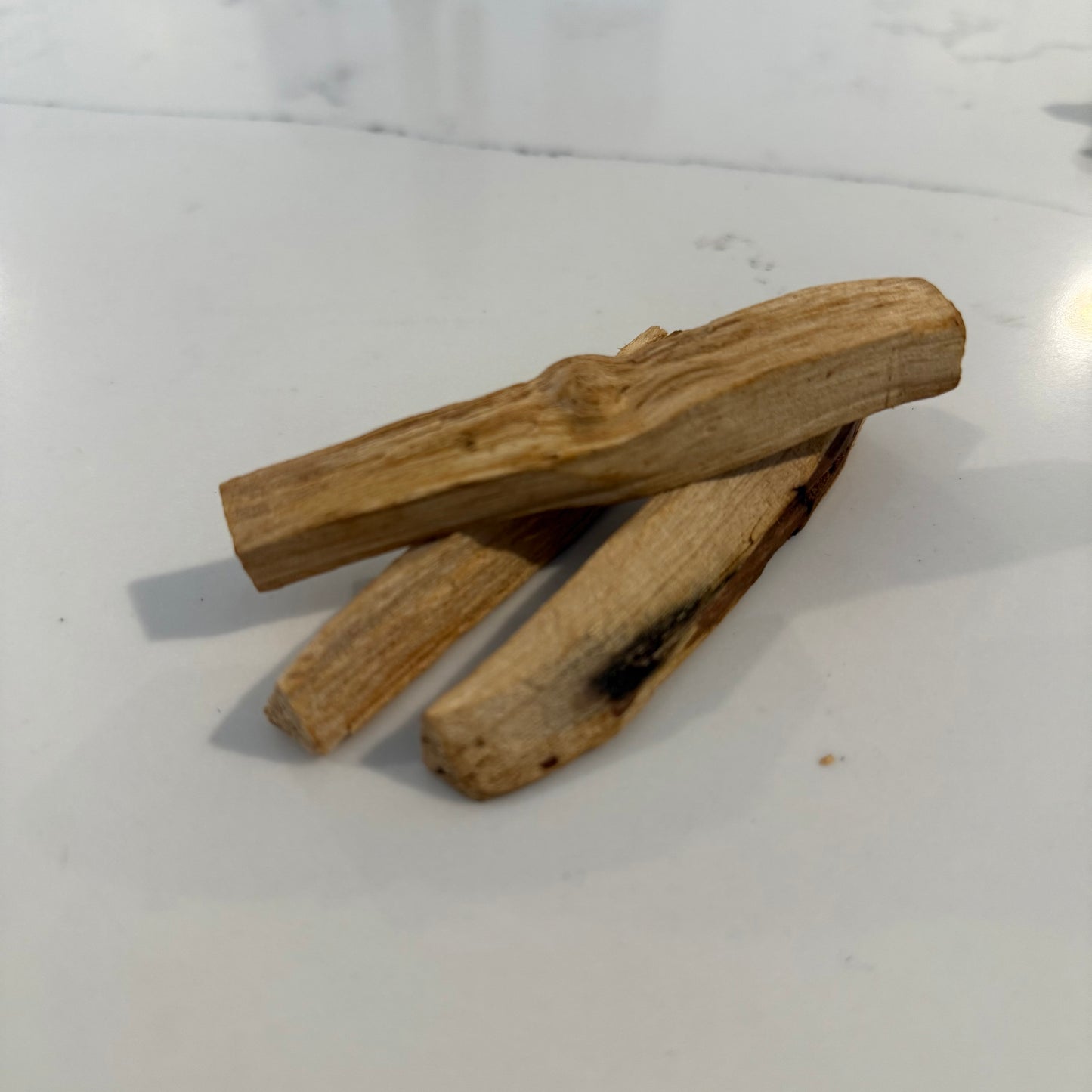 Three Palo Santo on a white surface