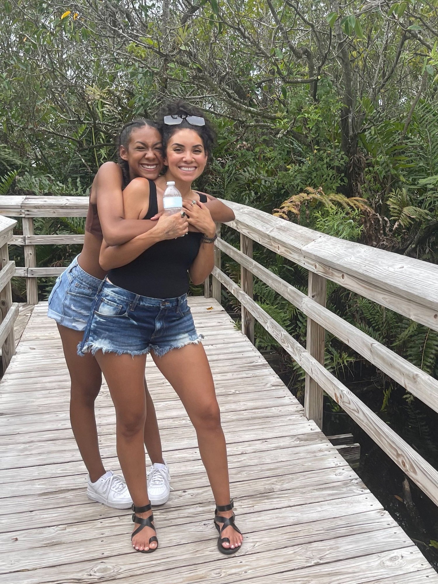 Mother and Daughter Founders of Organically Kismet Sea Moss embracing on bridge smiling.