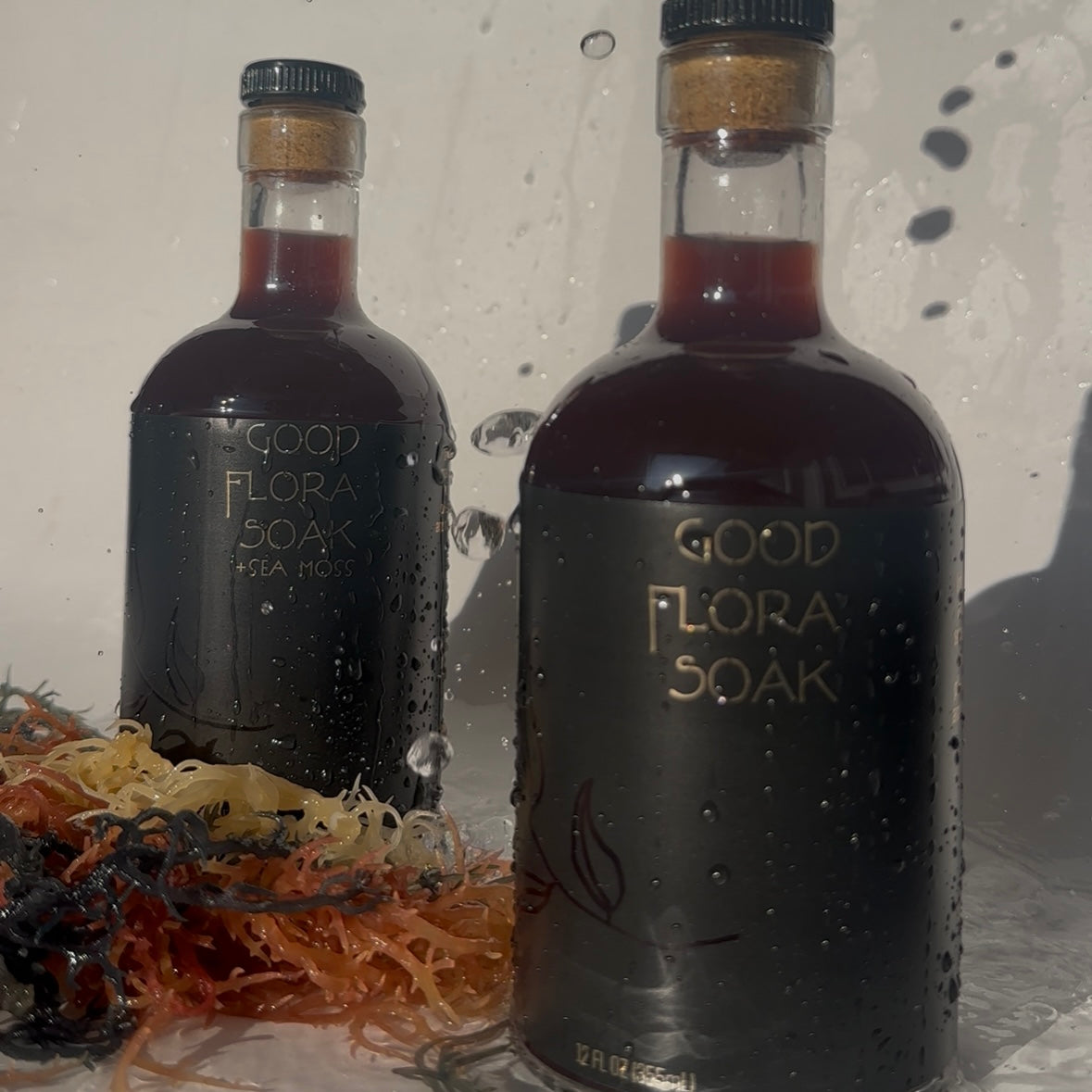 Good Flora Soak by Organically Kismet – premium sea moss infusion in dark glass bottles with raw sea moss in the foreground. A mineral-rich wellness soak crafted to restore balance, detoxify, and nourish the body.