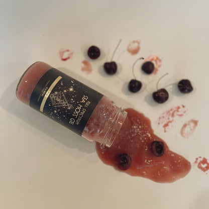 Organically Kismet Yin Sea Moss Gel spilled with whole cherries and cherry puree on a white surface, showcasing its rich color and natural ingredients.